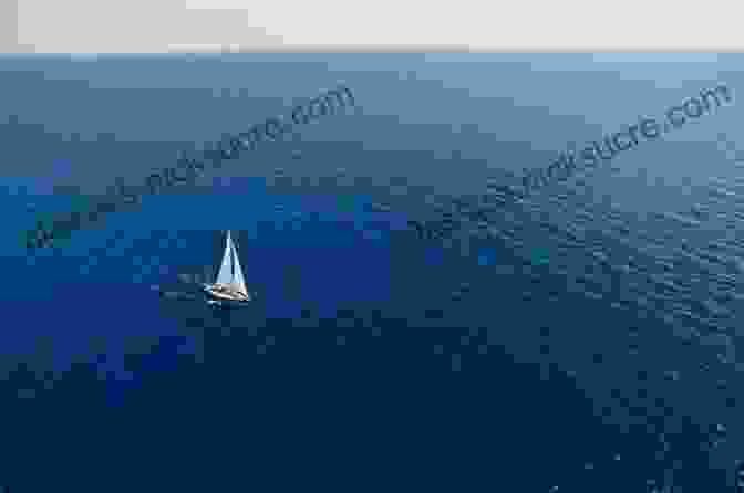A Lone Sailboat Sails Across A Vast Ocean Under A Clear Blue Sky. The Lonely Sea And The Sky